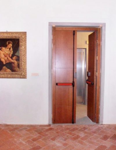 Porta in legno di noce con maniglie anti panico, realizzata dalla Falegnameria Rangoni Basilio per la Galleria degli Uffizi di Firenze.