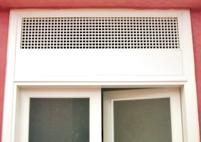 Dettaglio della scatola di ventilazione di una porta vetrata laccata bianco, realizzata dalla Falegnameria Rangoni Basilio per La Fabbrica del comune di Scandicci.