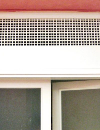 Dettaglio della scatola di ventilazione di una porta vetrata laccata bianco, realizzata dalla Falegnameria Rangoni Basilio per La Fabbrica del comune di Scandicci.