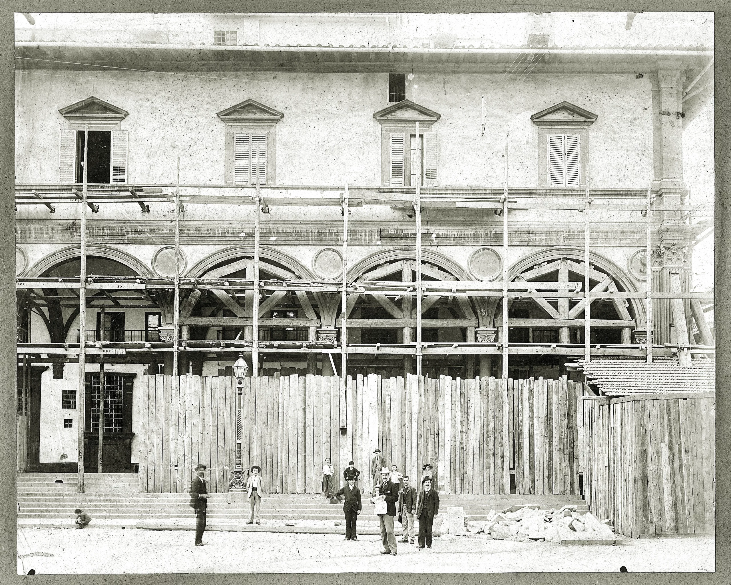 Fotografia storica del maestro Basilio Rangoni su un cantiere in Piazza Santa Annunziata a Firenze con alcuni operai nel XIX secolo